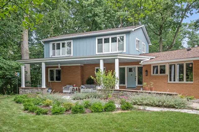Two-story home with a new covered front porch, white columns and updated exterior