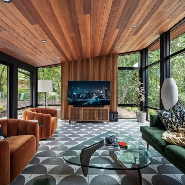 Addition with a cedar plank ceiling, floor-to-ceiling black-framed windows and a patterned tile floor